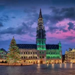 Panoramic view of the illuminated Grande place with City Hall in brussels, Belgium, decorated for Christmas with tree and lights during sunrise without people
